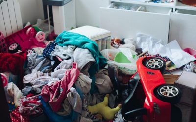 Messy room and disorder concept in the living room or bedroom. Scattered clothes and stuff on the floor.